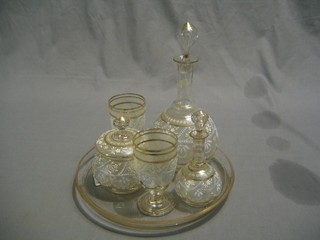 A glass cabaret set comprising circular glass tray, spirit decanter, wine decanter, 2 goblets and a jar and cover