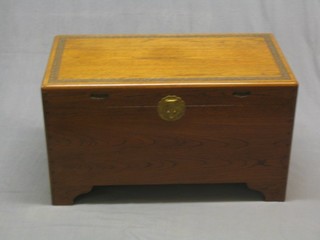 A 20th Century camphor wood coffer with hinged lid, having light carving to the top, raised on bracket feet 26"