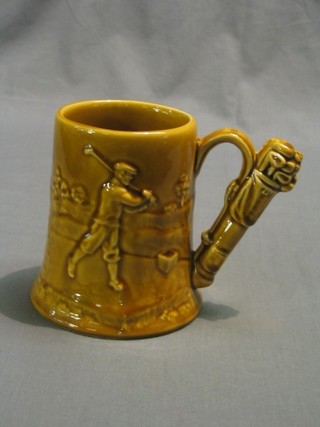 A 1930's treacle glazed pottery tankard decorated a golfer and with golfing motif to handle 5 1/2"