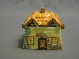 A Cottageware pottery biscuit barrel with raffia work handle 6"