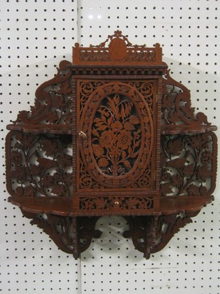 A fret work mahogany hanging cabinet flanked by 2 shelves, decorated birds amidst branches 20"