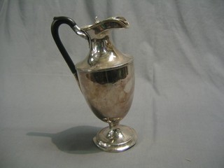 A Britannia metal hotwater jug raised on a circular foot