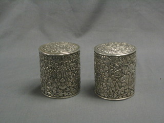 A pair of Eastern embossed silver cylindrical jars and covers 12 ozs