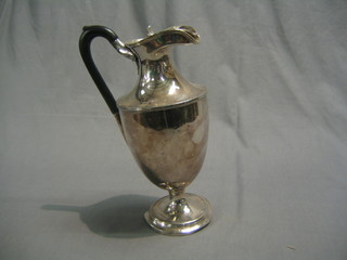 A Britannia metal hotwater jug raised on a circular spreading foot