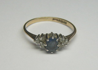 A lady's 9ct gold dress ring set a sapphire, surrounded by 6 white stones