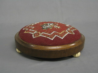 A Victorian circular mahogany footstool with bead work decoration, raised on 3 ceramic bun feet 12"