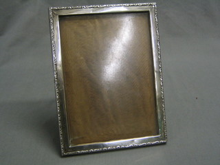 A rectangular embossed silver easel photograph frame, Birmingham 1934, 8" x 6"