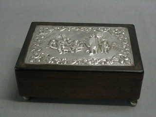 A rectangular Dutch Cedar cigar box, the top with embossed silver panel of a feasting scene with violinist, 6" x 5", raised on 4 bun feet