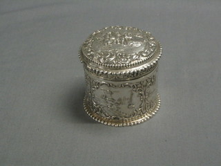 A cylindrical "Dutch" embossed silver jar with hinged lid decorated a canal scene 3",       4 ozs 