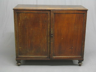 A 19th Century mahogany cabinet with shelved interior enclosed by panelled doors raised on bun feet 43"