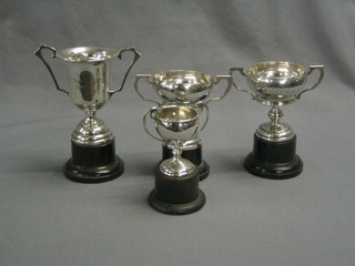 4 small silver twin handled trophy cups