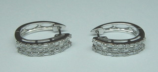 A pair of lady's 18ct white gold earrings set 5 baguette cut diamonds interspaced with 4 circular cut diamonds and supported by 10 diamonds (approx 0.80 ct)