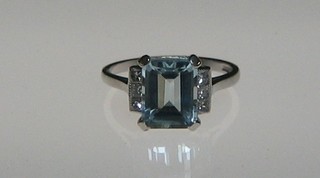 A lady's 18ct white gold dress ring set a rectangular aquamarine supported by 6 diamonds to the shoulders
