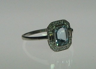 A lady's 18ct white gold dress ring set a rectangular cut aquamarine supported by 2 baguette cut diamonds and 18 further diamonds