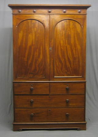 A Victorian mahogany linen press with moulded cornice, the  upper section fitted 3 shelves enclosed by arch shaped panelled doors, the base fitted 2 short and 2 long drawers, raised on a platform base 51"