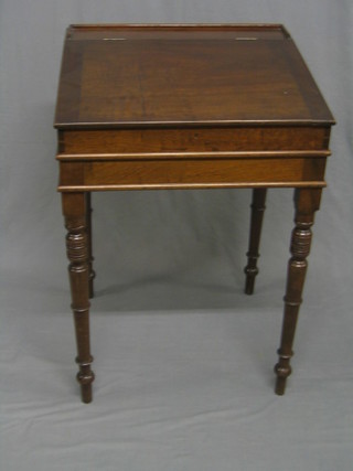 A 19th Century mahogany clerk's slope with hinged lid, raised on ring turned supports 22"