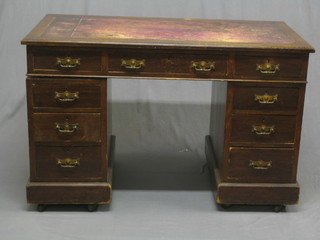 A walnut kneehole pedestal desk with inset tooled leather writing surface above 1 long and 8 short drawers 48"