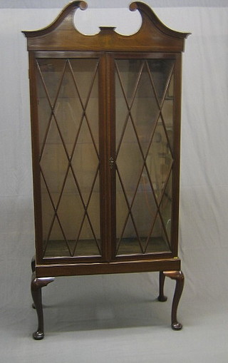 A Victorian mahogany bookcase with broken pediment, the interior fitted adjustable shelves enclosed by astragal glazed doors, raised on a somewhat later base on cabriole supports 35"