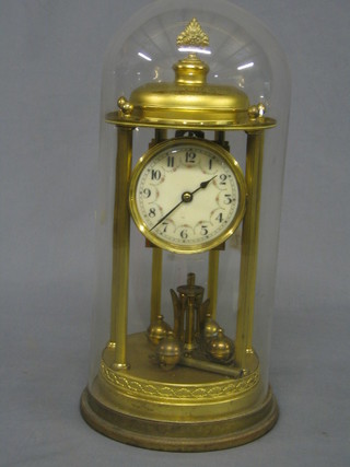 An Edwardian 400 day clock with enamelled dial and Roman numerals contained beneath a glass dome supported by gilt reeded columns