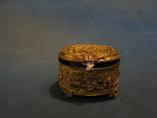 An oval 19th Century gilt metal trinket box with hinged lid decorated hunting and woodland scenes, raised on 4 pierced panel supports 4"