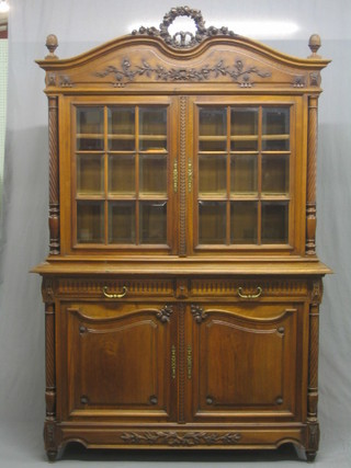 A 19th Century French walnut cabinet on cabinet, the upper section carved rose wreath, the interior fitted adjustable shelves enclosed by bevelled plate panelled doors, the base fitted 2 short drawers above a double cupboard, raised on turned supports 55" (reduced in height)