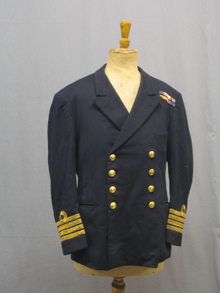 A Royal Navy Lieutenant commander's tunic and trousers by Bernard & Sons together with a Gieves & Hawkes peaked cap