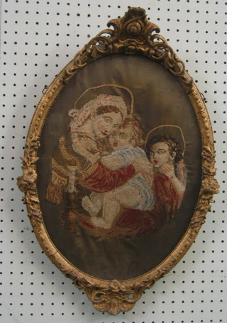 An oval Berlin wool work panel depicting the Holy Family 16" oval, contained in a decorative gilt frame