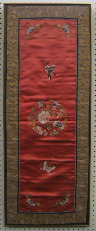 An Oriental red silk panel with embroidered decoration depicting butterflies and flowers, 33" x 12"