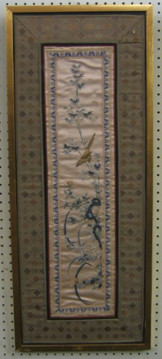 A 19th/20th Century Oriental silk panel decorated birds amidst branches 28" x 11", contained in a gilt frame
