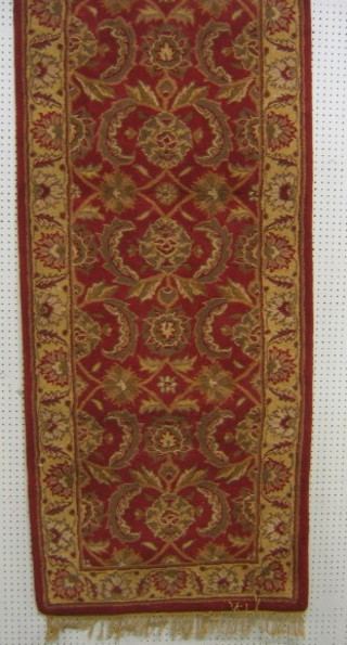 A contemporary red and gold ground Ziegler runner 96" x 32"