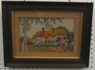 A 1930's wool work picture of a country cottage and garden 6" x 8" contained in an oak frame