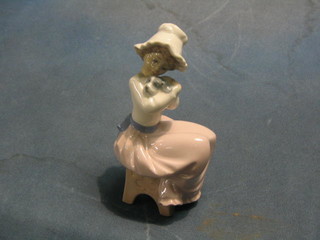 A Nao figure of a seated lady cradling a puppy 7" (head f and r)