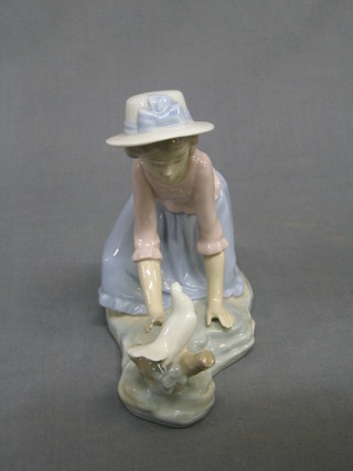 A Nao figure of a kneeling girl with bird (head f and r, tail f) 6"