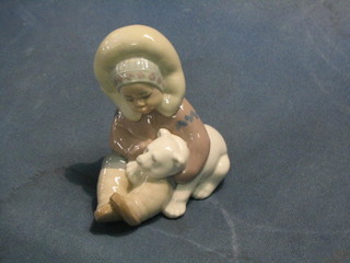 A Lladro figure of a seated Eskimo child with baby polar bear, base impressed 4-9N 5"