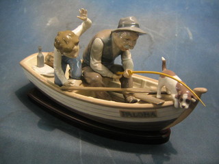 A Lladro figure group of Grandfather and Grandson in a fishing boat Palona together with a dog, the base marked 5215, raised on a wooden base 