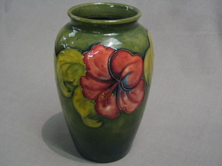 A Moorcroft Hibiscus pattern green glazed vase, the base impressed Moorcroft and with paper label, Potter to HM The Queen 8 1/2"