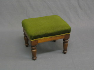 A Victorian rectangular mahogany footstool upholstered in green material, raised on turned supports 14"