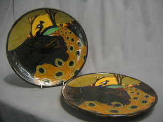 A pair of Art Nouveau Majolica pottery chargers decorated peacocks, 12"
