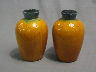A pair of treacle glazed Art Pottery vases of club form, base incised B, 6 1/2"