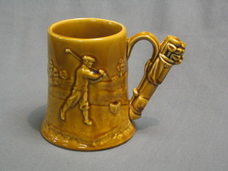 A 1930's treacle glazed pottery tankard decorated a golfer and with golfing motif to handle 5 1/2"