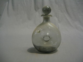 A doughnut shaped clear glass decanter and stopper 10"
