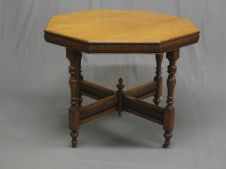 An Arts & Crafts honey oak octagonal centre table raised on turned supports united by an X framed stretcher 35"