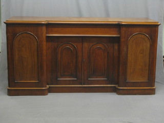 A Victorian mahogany inverted break front sideboard, fitted 1 long drawer above a double cupboard, flanked  by a pair of panel doors enclosed by arched panelled doors, raised on a platform base 71"