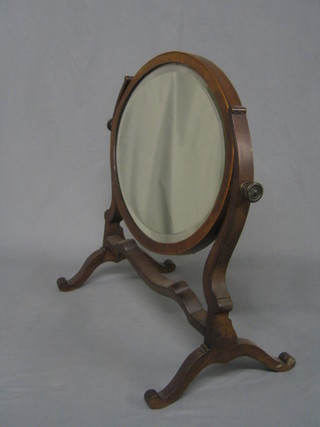 A 19th Century oval bevelled plate dressing table mirror contained in a mahogany swing frame (some spotting to mirror back)