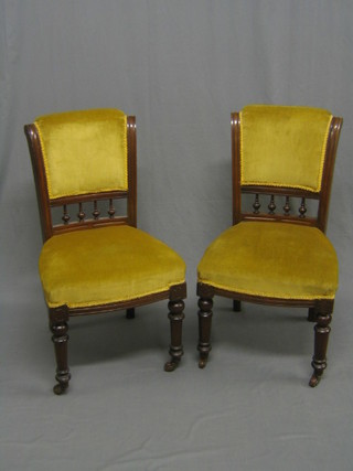 A pair of Edwardian walnut dining chairs with bobbin turned decoration, upholstered in gold Dralon (1 with old break and repair to back)
