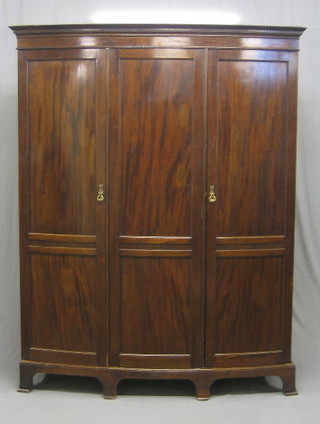 A 19th/20th Century mahogany bow front triple wardrobe with moulded cornice and fitted interior, raised on splayed bracket feet, 62"