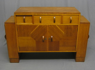 An Art Deco honey oak sideboard fitted 1 long drawer flanked by 2 short drawers, the base fitted a double cupboard, the sides fitted cupboards enclosed by panelled doors, 5"