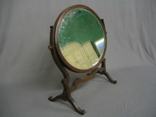 A 19th Century oval bevelled plate dressing table mirror contained in a mahogany swing frame 17"