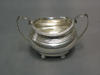A Georgian style oval silver twin handled sugar bowl raised on 4 bun feet, Birmingham 1920, 4 ozs