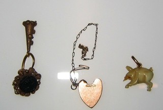 An ivory charm in the form of an elephant, a 9ct gold miniature heart shaped padlock and a small gold pendant